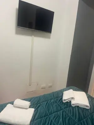 a bedroom with a bed with a tv on the wall at Appartamento int 1 in Rome