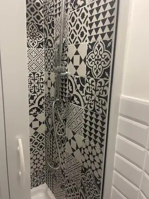 a bathroom with black and white tiles on the wall at Appartamento int 1 in Rome