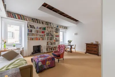 a living room with a large book wall at iFlat The Carpet Apartment in Rome