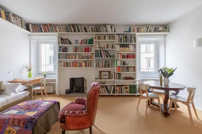 a living room with a large book shelf filled with books at iFlat The Carpet Apartment in Rome