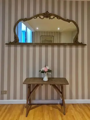 a table with a mirror and a vase of flowers on it at Navona Gold Apartment in Rome