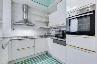 a white kitchen with a sink and a stove at BMGA l Luxury 3Bdr Apt with Stunning View in City Center in Rome