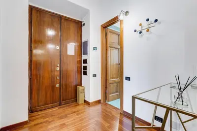 a hallway with a wooden door and a glass table at BMGA l Luxury 3Bdr Apt with Stunning View in City Center in Rome