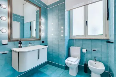 a blue bathroom with a sink and a toilet at BMGA l Luxury 3Bdr Apt with Stunning View in City Center in Rome