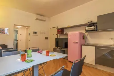 a kitchen with a table and a pink refrigerator at iFlat Apê Ponte Sisto in Rome