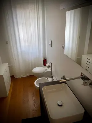 a bathroom with a sink and a toilet and a mirror at Garden house in Rome