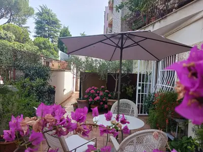 a table with an umbrella and some purple flowers at Garden house in Rome