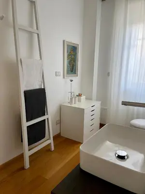 a white room with a bed and a ladder at Garden house in Rome