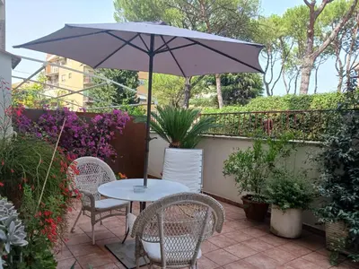 a table and chairs with an umbrella on a patio at Garden house in Rome