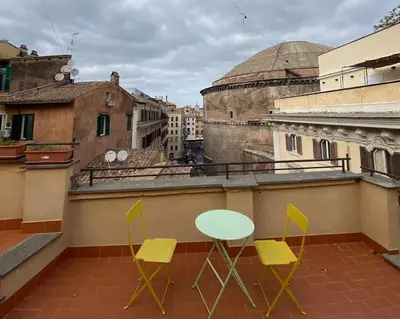 a balcony with two chairs and a table on a roof at Pantheon Design Apartment in Rome
