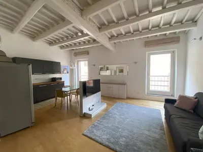a living room with a couch and a table and a kitchen at Pantheon Design Apartment in Rome
