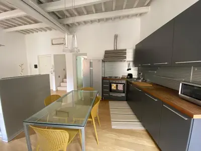 a kitchen with a glass table and yellow chairs at Pantheon Design Apartment in Rome