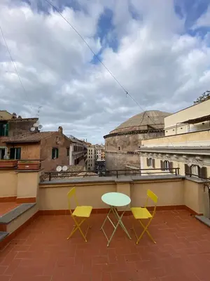 a patio with two chairs and a table on a roof at Pantheon Design Apartment in Rome