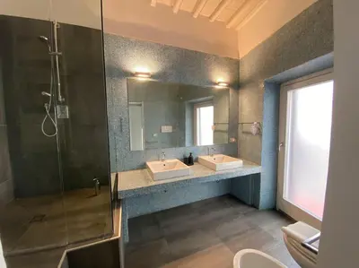 a bathroom with two sinks and a shower and a mirror at Pantheon Design Apartment in Rome