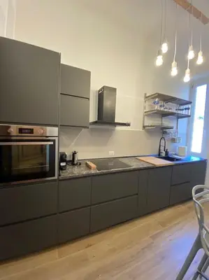 a kitchen with stainless steel appliances and a wooden floor at Trastevere Design Apartment in Rome