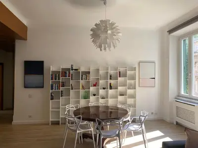 a dining room with a table and chairs and a chandelier at Trastevere Design Apartment in Rome