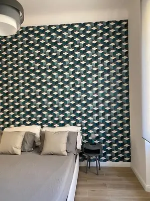 a bedroom with a bed with a wall covered in at Trastevere Design Apartment in Rome