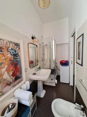 a bathroom with a sink and a toilet and a mirror at Amina's House Lab in Rome