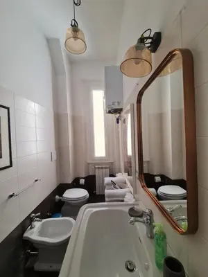 a bathroom with a sink and a toilet and a mirror at Amina's House Lab in Rome