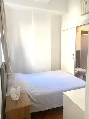 a white bedroom with a bed and a sink at Pariolina in Rome
