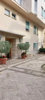 a building with two potted trees in front of it at Pariolina in Rome