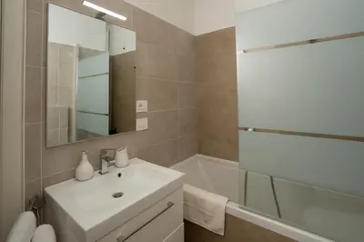 a bathroom with a sink and a tub and a mirror at Ancient Rome Apartment in Rome