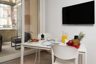a white dining room with a table with food on it at Ancient Rome Apartment in Rome