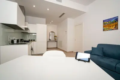 a living room with a blue couch and a kitchen at Ancient Rome Apartment in Rome