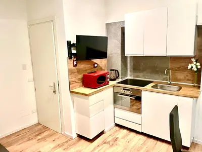 a kitchen with white cabinets and a red appliance on a counter at Vatican Suite 