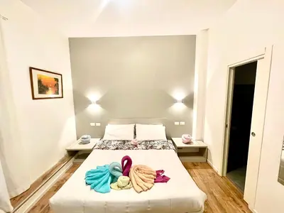 a bedroom with a bed with flip flops on it at Vatican Suite 