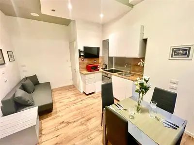 a living room with a dining table and a kitchen at Vatican Suite 