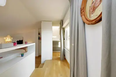 a hallway with white walls and wood floors and a window at Beautiful Loft in Ponte Milvio with terrace in Rome