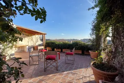 a patio with chairs and a table and avisor at Beautiful Loft in Ponte Milvio with terrace in Rome