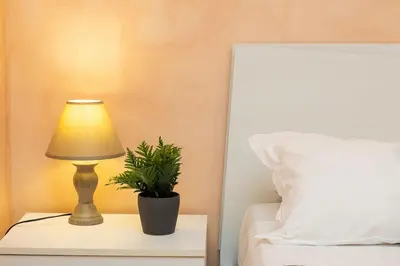 a lamp sitting on a night stand next to a bed at Trastevere Home by Rental in Rome in Rome