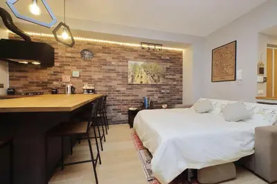 a bedroom with a bed and a kitchen with a bar at Casina degli Eroi in Rome