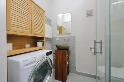 a small kitchen with a washing machine and a glass door at Casina degli Eroi in Rome