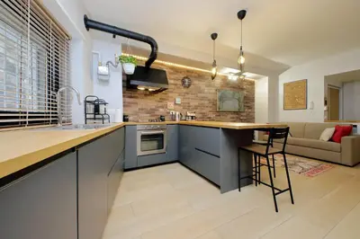 a kitchen with a counter and a living room at Casina degli Eroi in Rome