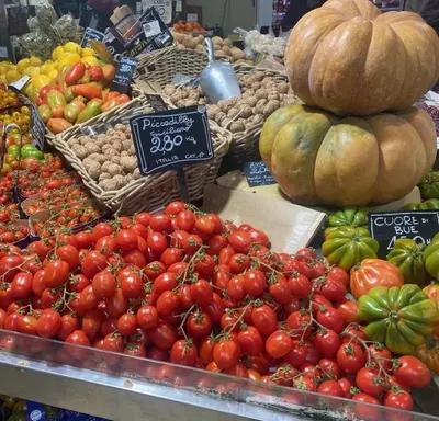 a display of tomatoes and other fruits and vegetables in a market at Casina degli Eroi in Rome