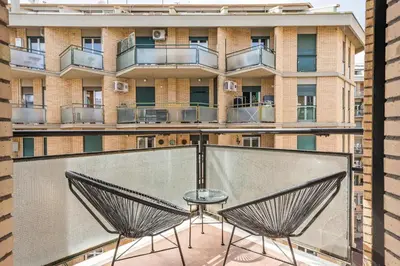 a balcony with two chairs and a table in front of a building at Trastevere Boutique Apartment in Rome