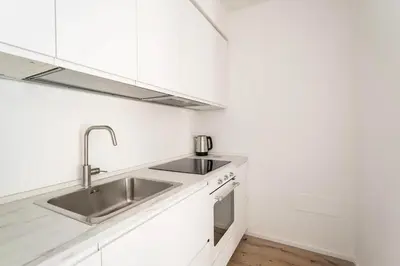 a kitchen with white cabinets and a sink at Trastevere Boutique Apartment in Rome