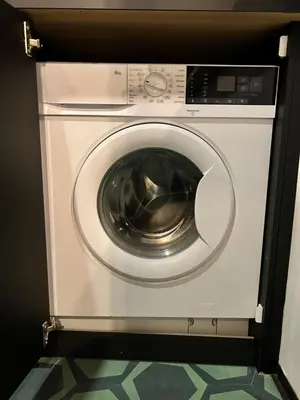 a white washing machine in a room with a green floor at Appartamento nel cuore di Roma in Rome
