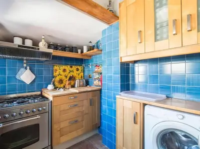 a blue tiled kitchen with a washing machine at Panoramic Terrace Trastevere in Rome