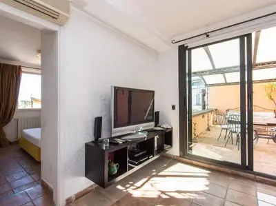 a living room with a flat screen tv and a balcony at Panoramic Terrace Trastevere in Rome