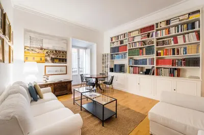 a living room with a white couch and a table at Maison Regola, Styilish Apt in Campo De Fiori in Rome