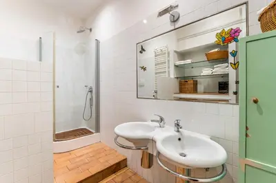 a white bathroom with a sink and a shower at Maison Regola, Styilish Apt in Campo De Fiori in Rome