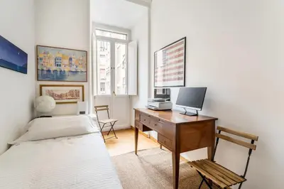 a bedroom with a bed and a desk with a computer at Maison Regola, Styilish Apt in Campo De Fiori in Rome
