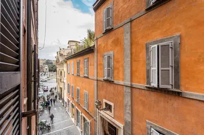 a group of people walking down a street between buildings at Maison Regola, Styilish Apt in Campo De Fiori in Rome