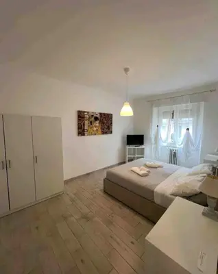 a large white bedroom with a bed and a table at Bignami street in Rome