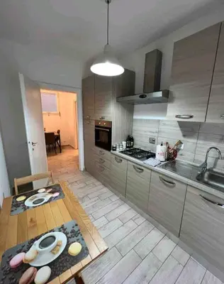 a kitchen with a wooden table and a kitchen with a sink at Bignami street in Rome