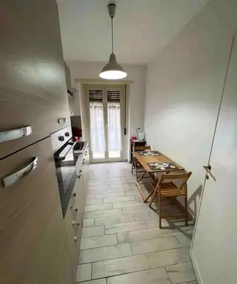 a kitchen with a table and a dining room at Bignami street in Rome